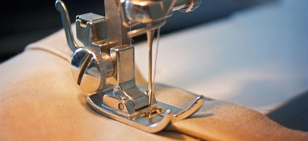 Detail šicího stroje při úpravě oděvu